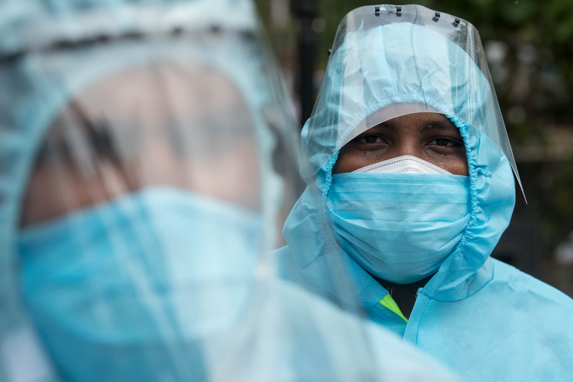 Two people in protective clothing and face masks