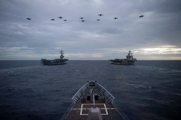 Aircraft soar above aircraft carrier group