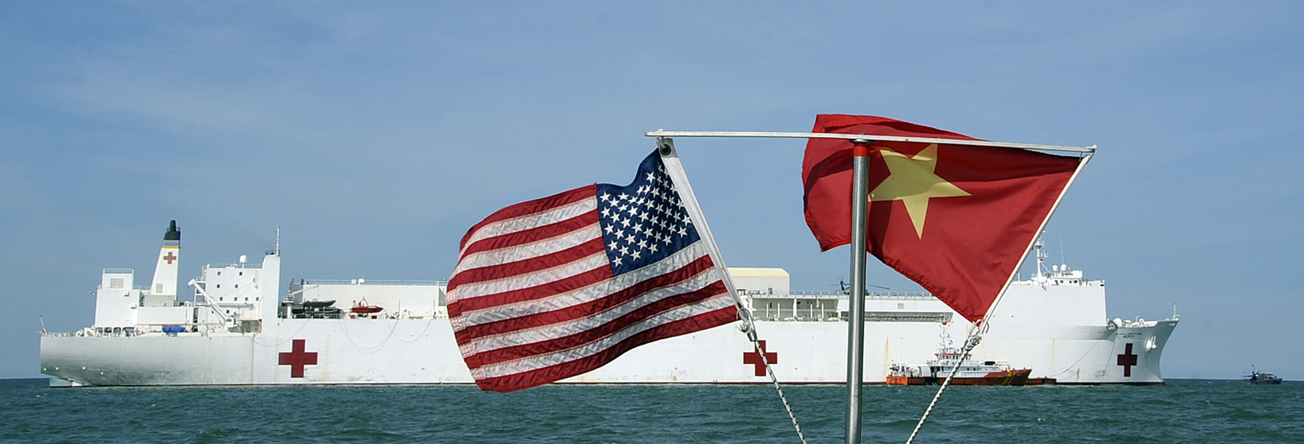 U.S. and Vietnamese flags fly in unison as the Military Sealift Command hospital ship USNS Mercy (T-AH 19) sits on station