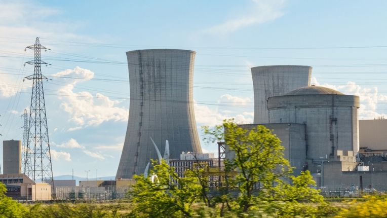 A nuclear power plant stands tall in the middle of a vast field