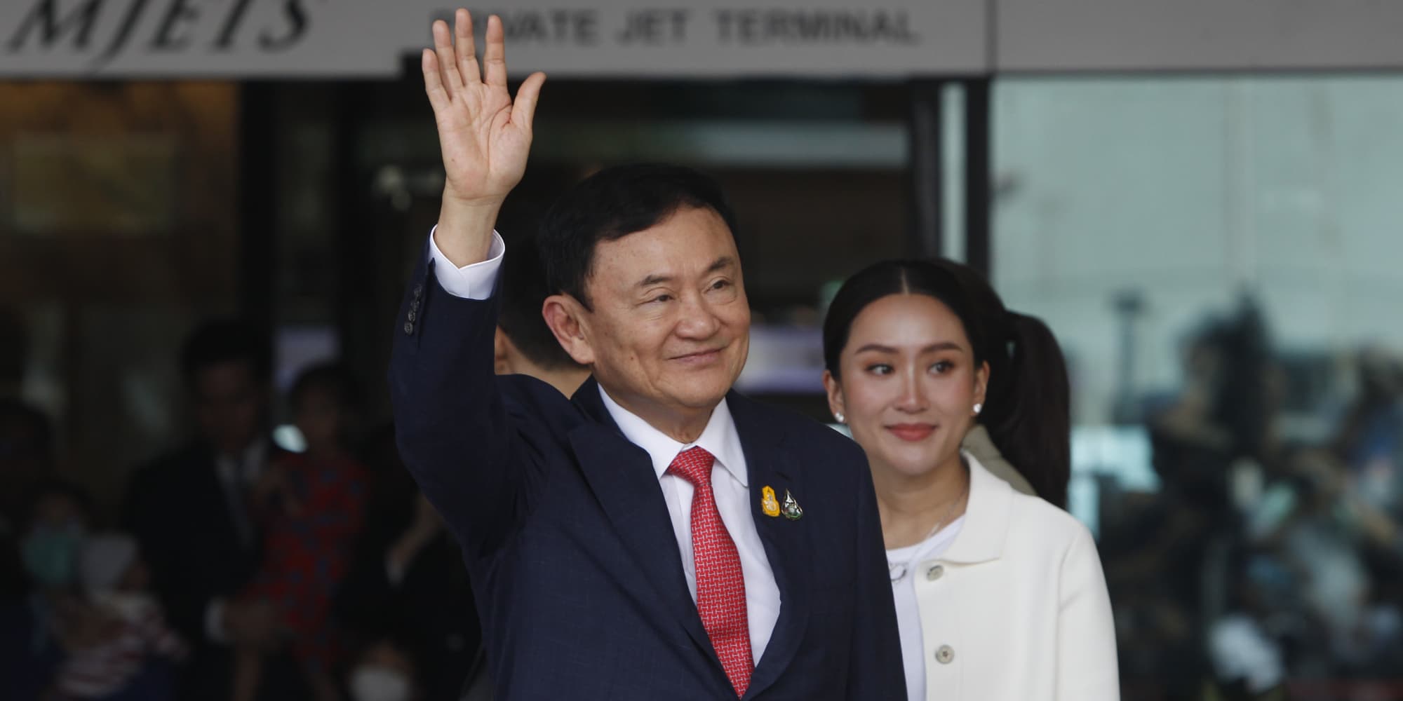 Thai former prime minister Thaksin Shinawatra and daughter Paetongtarn Shinawatra greet supporters