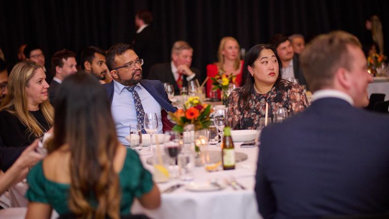 Attendees seated at tables for a gala dinner