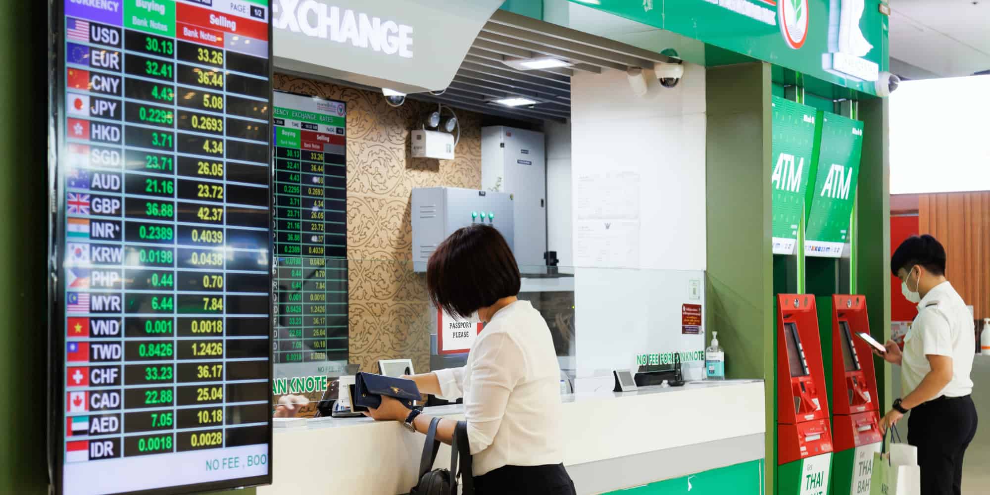 A woman stands at a bank counter