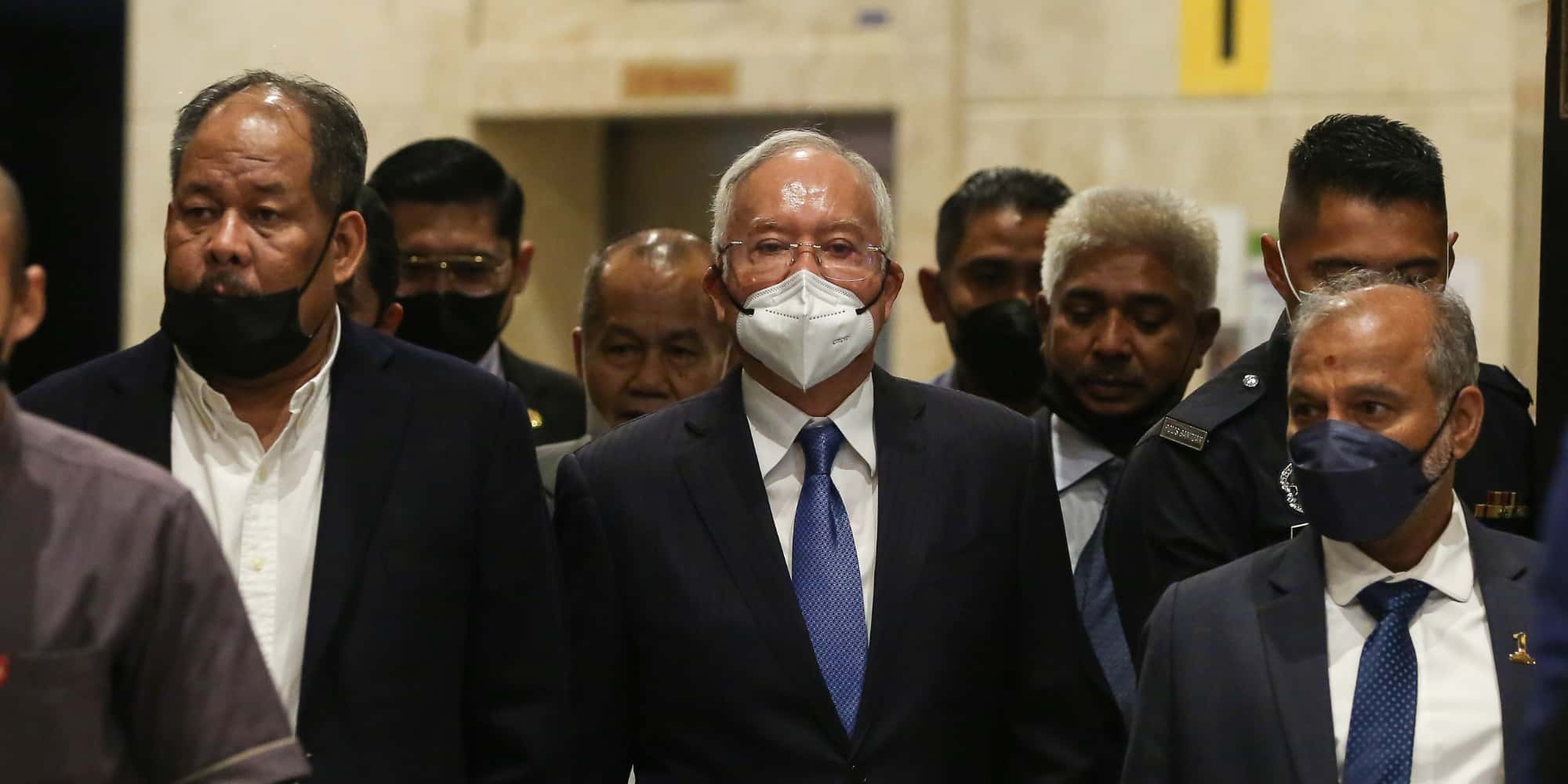 Najib Razak walking along with men in suits