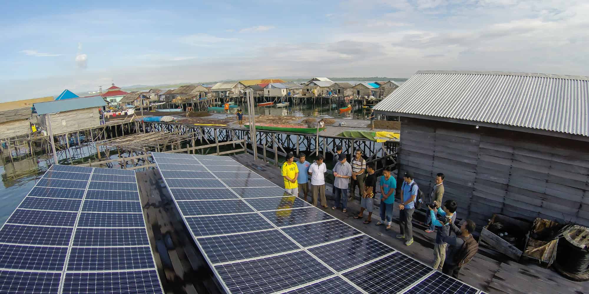 A group of people standing around solar panels