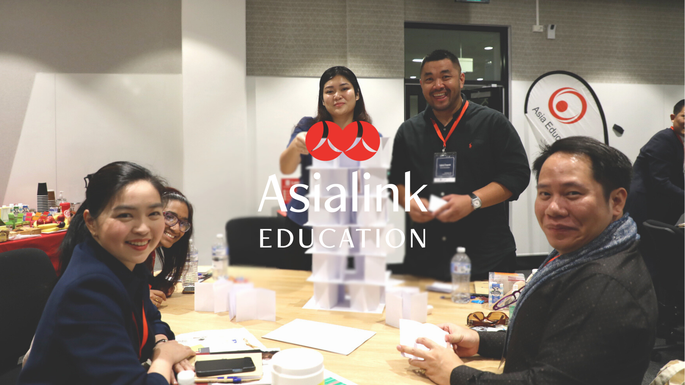 A group of people sitting around a table, engaged in a collaborative activity.