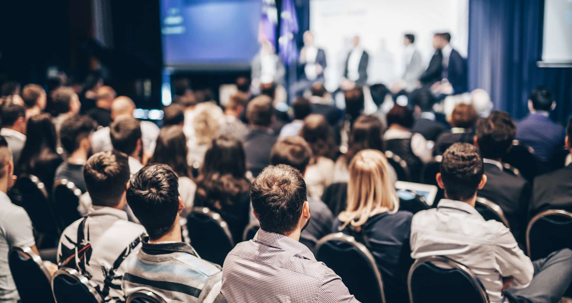An audience views speakers on a stage