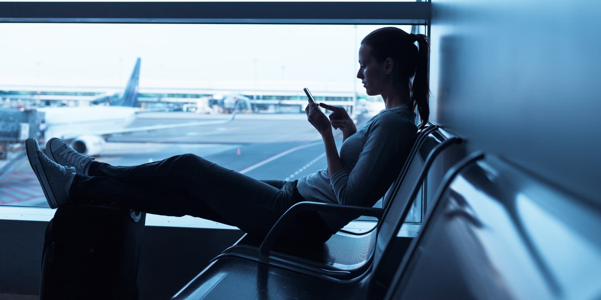 A woman looking at her phone at the airport