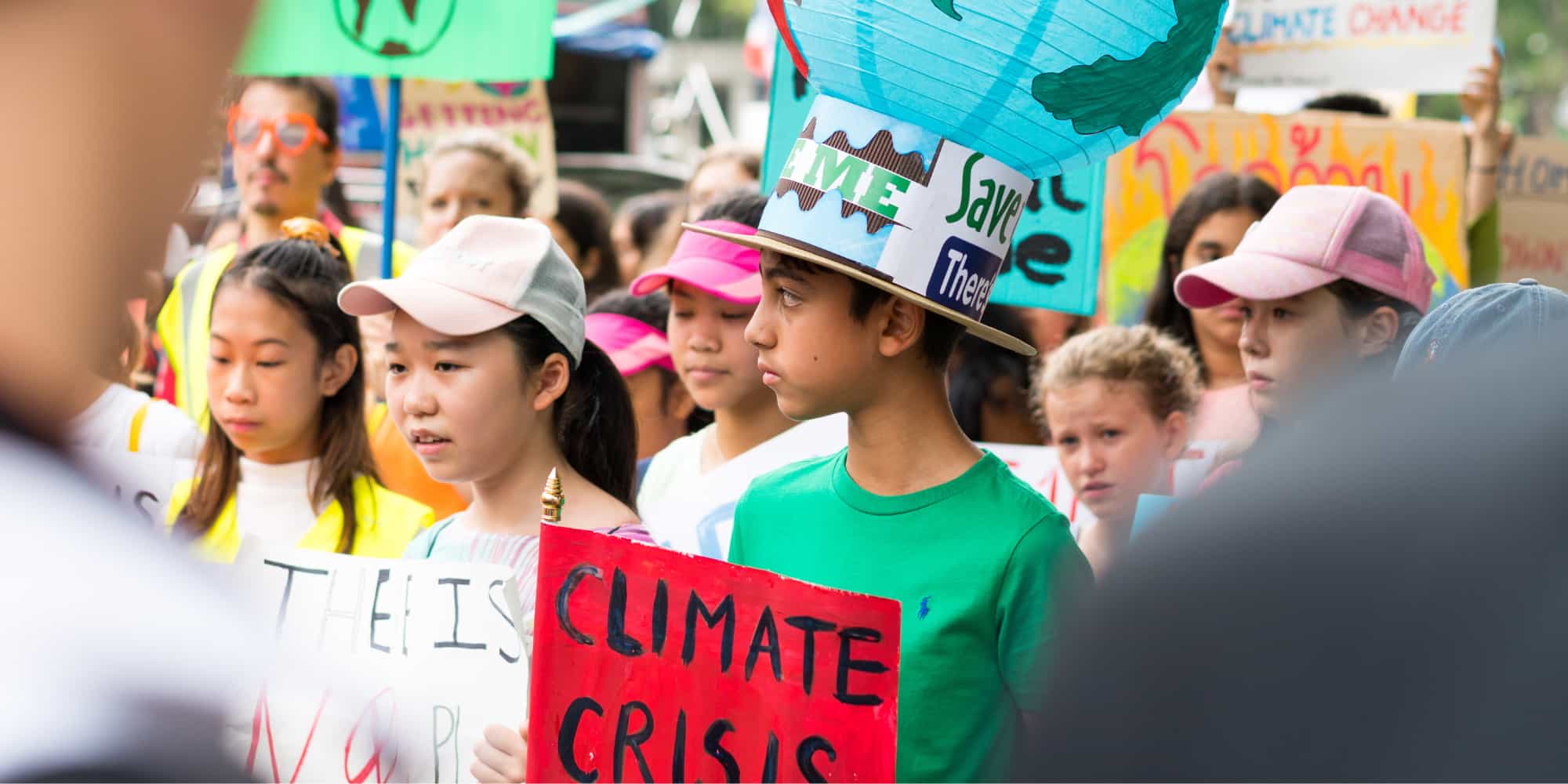 People and young school children, march in Youth Global Climate Strike with signs about climate crisis