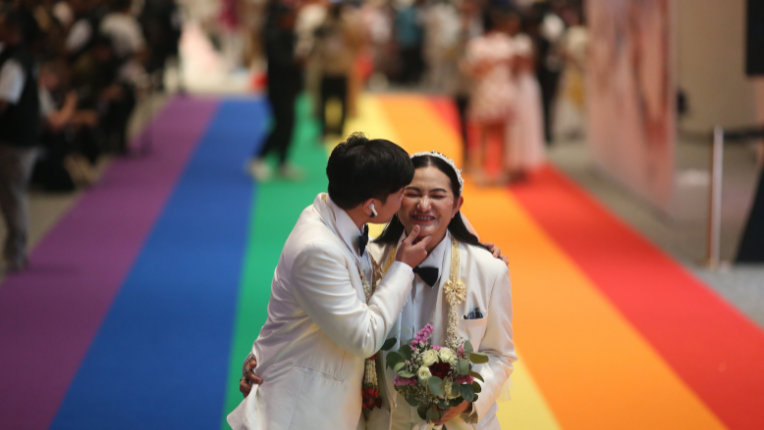 Couple getting married on rainbow carpet